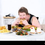 Fat man eating a lot of unhealthy food, on home interior backgro