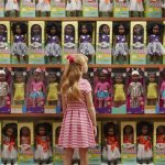 Flip the script; white girl looks at rows of black dolls JPP