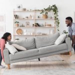 Black Couple Moving Sofa In Living Room Replacing Furniture At H