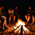 people sitting around a campfire