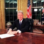 Bill Clinton sitting at a desk