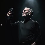 Man holding iphone on stage