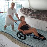 Man pushing woman into pool wheelchair
