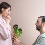 Man offering vegtables to woman