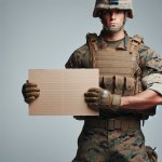 caucasian American marine holding up blank cardboard sign