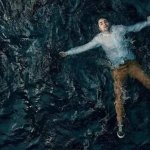 MAN FLOATING IN THE OCEAN
