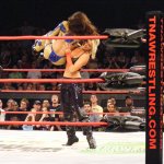 Female wrestler chokeslamming another female wrestler