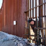illegal alien peeking through border wall