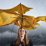 a person holding a broken umbrella in the rain
