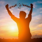 Man breaking free from chains over the sunset