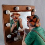 Clown applying makeup in mirror