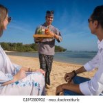 Couple on the beach being served