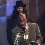 Snoop Dogg standing behind Tupac.