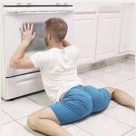 Man laying down looking in oven