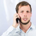 Concerned man holding phone to ear