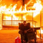 Hangman sitting over burnt house