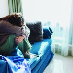 crying depressed woman on sofa