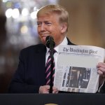 Trump holds up newspaper meme