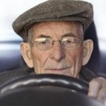 Old man with hat driving