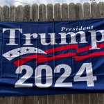 Trump 2024 flag on fence