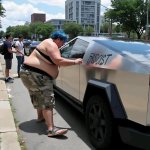 Wokester vandalizing a Tesla