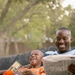 dad reading newspaper kid laughing
