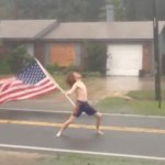 Guy standing in storm with american flag