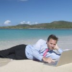 guy on beach with laptop
