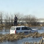 Cop on car in river