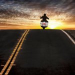 Guy riding motorcycle into the sunset