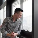man looking out of window