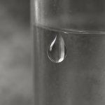 A drop of water clinging to the side of a glass.