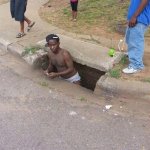 Guy coming out of sewer