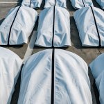 Rows of body bags in a parking lot
