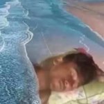 Guy sleeping *in* the beach