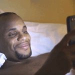 Black guy smiling at phone