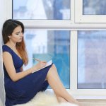Woman writes at window