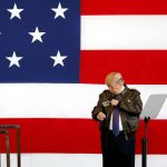 trump low iq stands in front of flag