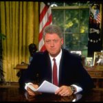 Bill Clinton behind Oval Office desk