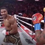 Anthony Joshua smiling while knocking out Jake Paul