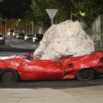 Broken car with concrete rock