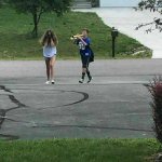 Kid blowing trumpet in sisters ear