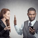 Guy looking at Phone and ignoring woman