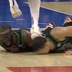 Man stepping on man's head on basketball court