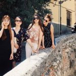 4 girls taking a photo while a naked guy approaches from afar