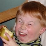 kid eating sour apple