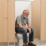 Elderly man westwall toe-tapping bathroom stall