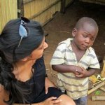 Incredulous little black kid looking up at white lady