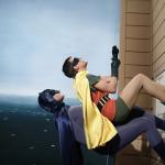 batman and robin climbing a building