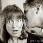 man whispering to woman